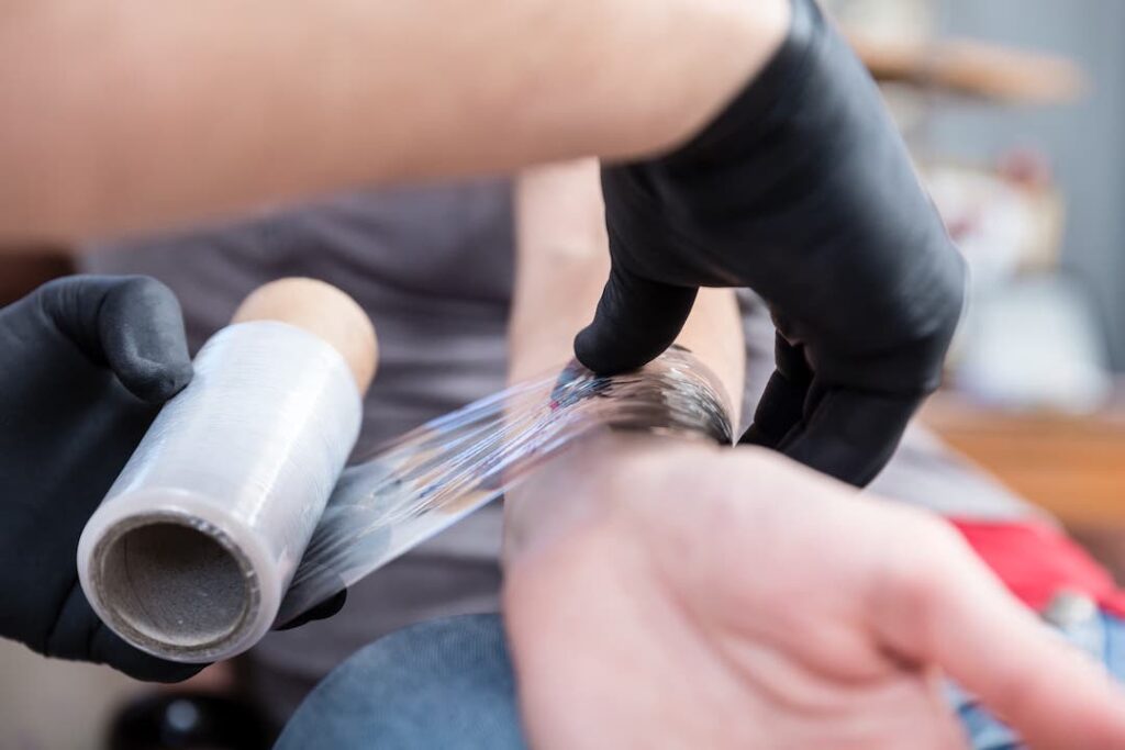 Plasma Tattoo Aftercare - Fresh tattoo being wrapped in cling wrap
