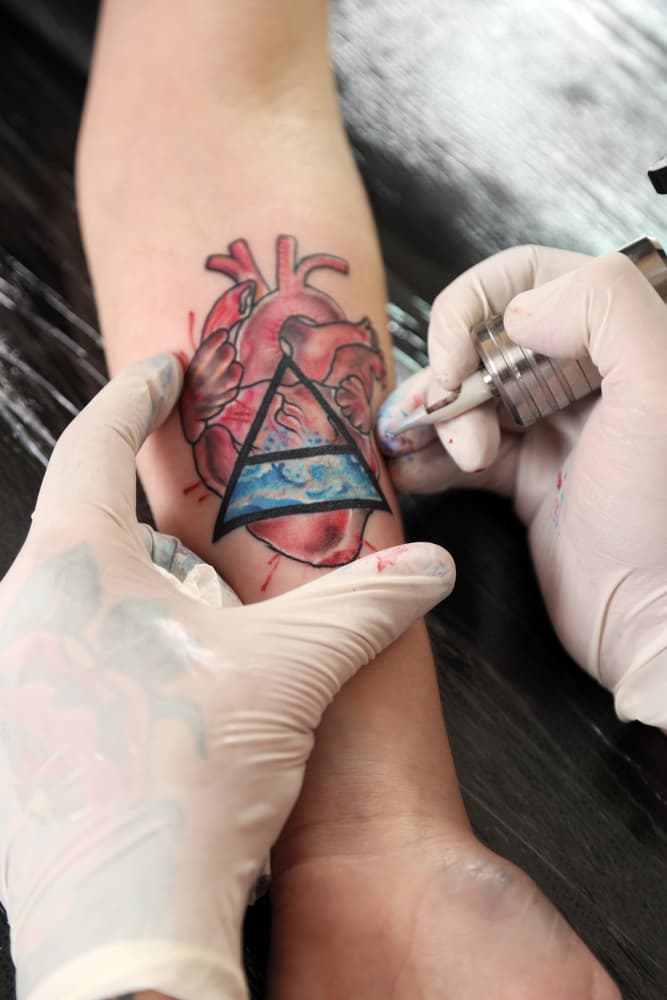 Tattoo artist at work on a cover up tattoo